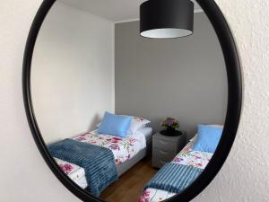 a mirror in a room with two beds and a bed at OKO NA ZATOKĘ in Puck