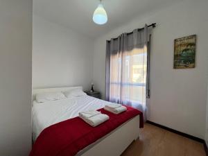 a bedroom with a white bed with a red blanket at OFIR NATURE in Fão