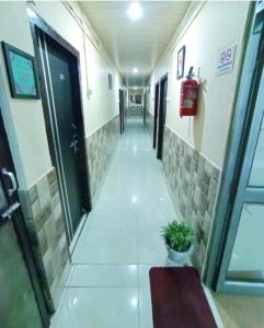 a hallway in a building with a door and a plant at D.D Lodge in Guwahati