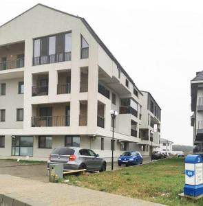 a large white building with cars parked in front of it at New cozy apartment in Otopeni near airport in Otopeni