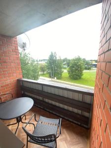 een balkon met een tafel en stoelen en een raam bij Feelings Apartment apartamenti Smiltene in Smiltene