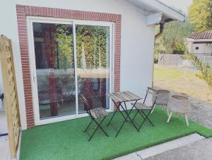 eine Gruppe Stühle und ein Tisch auf einer Terrasse in der Unterkunft La Maison de Maxou in Montauban