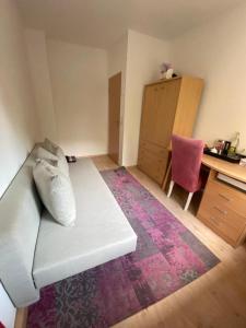 ein Wohnzimmer mit einem weißen Sofa und einem Schreibtisch in der Unterkunft Schönes Zimmer im charmanten Haus in Berlin