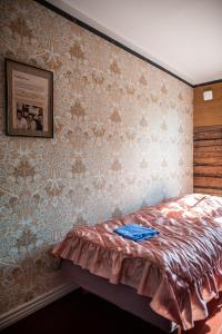 a bedroom with a bed with a picture on the wall at Matkustajakoti Ykspihlaja in Kokkola