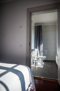 ein Schlafzimmer mit einem Bad mit einem Waschbecken und einem WC in der Unterkunft Matkustajakoti Ykspihlaja in Kokkola