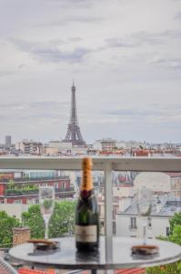 a bottle of wine sitting on a table with two glasses at Vue exceptionnelle sur la tour Eiffel in Paris