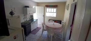 a kitchen with a table and a kitchen with a table and chairs at Casa na Praia da Pinheira in Palhoça