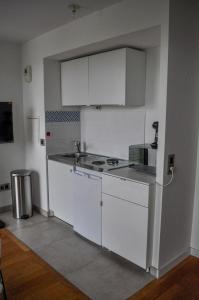 a white kitchen with a sink and a refrigerator at Vue exceptionnelle sur la tour Eiffel in Paris