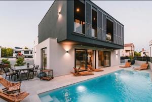 a house with a swimming pool in front of a house at Villa Casa Domina in Srima