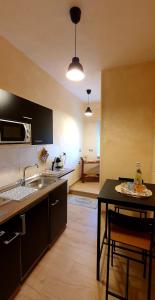 cocina con fregadero y mesa con sillas en Pacifico Rooms en San Bartolomeo in Galdo
