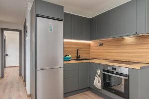 a kitchen with gray cabinets and a refrigerator at Blue Garden Samos Apartments in Samos