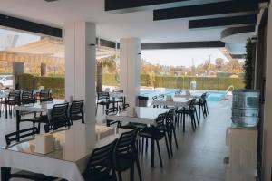 un restaurante con mesas y sillas y una piscina en PALMİLA BUTİK OTEL, en Silifke