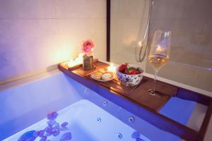 a bathroom with a bath tub with a glass of wine at Domaine du lion rouge in Coucy-le-Château-Auffrique