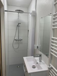 a white bathroom with a shower and a sink at Gîte du clocher dans ancienne maison du vignoble in Niedermorschwihr