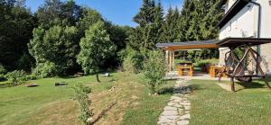 un patio trasero con una casa con cenador en Plitvice Inn en Jezerce