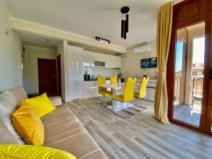a living room with a couch and a table with yellow chairs at Adria Sea & Mountains in Herceg-Novi