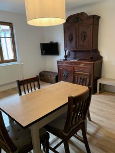 comedor con mesa de madera y sillas en Gîte du clocher dans ancienne maison du vignoble en Niedermorschwihr