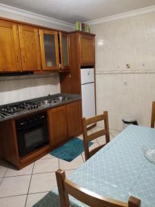 uma cozinha com um lavatório, um fogão e uma mesa em Bragança Home For Working, Tourists, Erasmus Students, Digital Nomads em Brangança