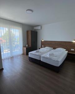 a bedroom with a large bed and a large window at Villa Forest Ohrid in Peštani