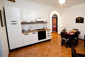 a kitchen with white cabinets and a table and a dining room at B&B Il Tiglio in Padula