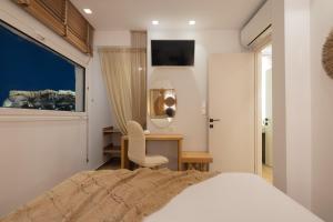 een slaapkamer met een bed, een bureau en een raam bij Apollonos at Heart of Plaka in Athene