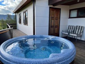 a jacuzzi tub on a deck with a house at Halakot guesthouse in Laugardælir