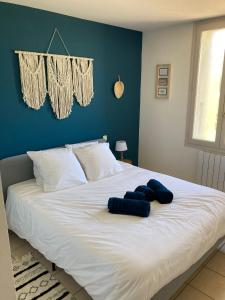 a large white bed with two blue pillows on it at Gite Le Canigou 3* dans un Mas typique catalan in Prades