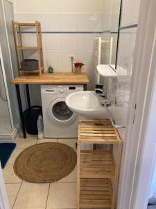 a bathroom with a sink and a washing machine at Gite Le Canigou 3* dans un Mas typique catalan in Prades
