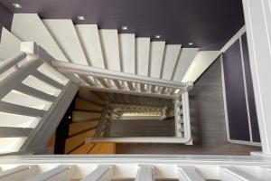 a spiral staircase in a building with white stairs at Les Embruns in Trouville-sur-Mer