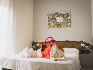 ein Bett mit einer Handtasche und Handtüchern darauf in der Unterkunft Minturnae Hotel in Scauri