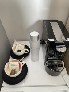 a kitchen counter with two cups of coffee and a toaster at Les Embruns in Trouville-sur-Mer