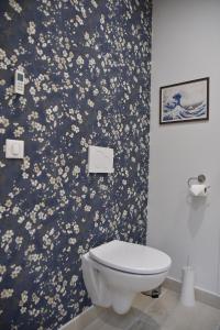 La salle de bains est pourvue de toilettes et de papier peint à fleurs. dans l'établissement L'escale du Gros Horloge, à Rouen