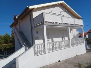 a white house with a balcony at Apartment Mia in Rab