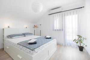 a white bedroom with a large bed in a room at Zola Guest House in Oradea