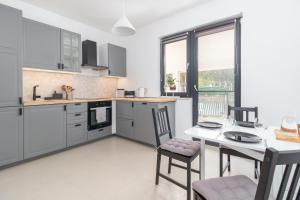 a kitchen with a table and two chairs and a table and a window at Zola Guest House in Oradea