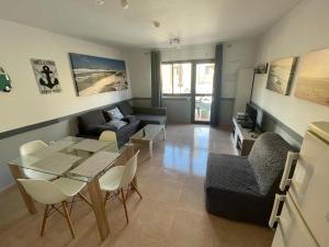 un soggiorno con tavolo e divano di Casa DENNY - Oasis Papagayo a Corralejo