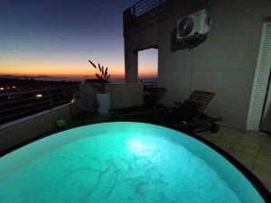 una vasca idromassaggio in cima a un edificio con tramonto di Fantasea Unique Resort a Kalathas