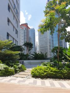 馬尼拉的住宿－Heart of Makati, Fully furnished condo, cbd central location，一座位于城市中心,拥有高楼的花园