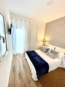 een witte slaapkamer met een groot bed en een raam bij Luxury Suite Sea Front V in Playa Honda