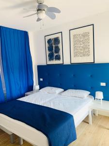 un letto con testiera blu in una camera da letto di DunaBlu a Duna Verde
