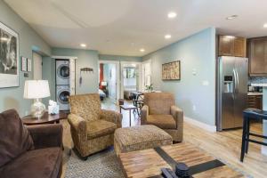 a living room with a couch and chairs and a kitchen at Fresh and Airy Condo in downtown Breck! in Breckenridge