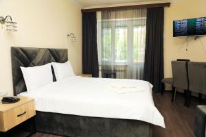 a hotel room with a large bed and a window at ARAGAST HOTEL & BREWERY пивоварня in Sevan