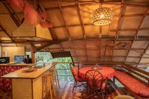 a kitchen with a table and chairs in a room at La Pirogue chez l'Happy qui chante in Haapiti
