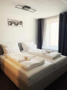 two white beds in a room with a window at Cozy Apartment Bernburg 3 in Roschwitz