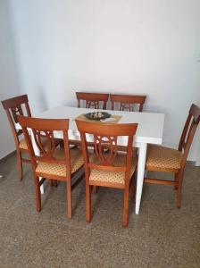 una mesa con sillas de madera, una mesa blanca, una mesa y un sillón en Sun & Sea 3 Bedroom Apartment de Grau, en Gandía