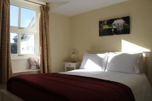 a bedroom with a bed with white pillows and a window at Belle Green Bed and Breakfast in Sawrey
