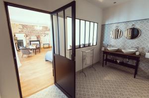 a room with a bathroom with a sink and a mirror at Domaine du lion rouge in Coucy-le-Château-Auffrique