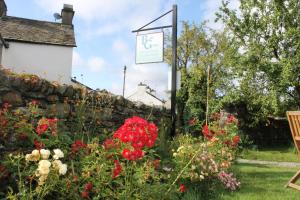 a garden with flowers and a stone wall at Belle Green Bed and Breakfast in Sawrey