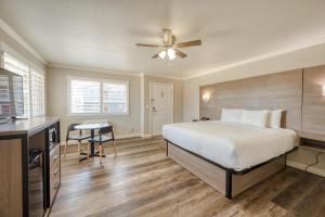 a bedroom with a bed and a desk and a ceiling fan at Harbor House Inn in Morro Bay