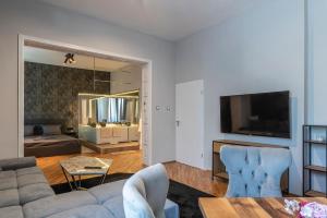 ein Wohnzimmer mit Sofa und Fernseher in der Unterkunft Luxury Vitosha Apartment in Sofia